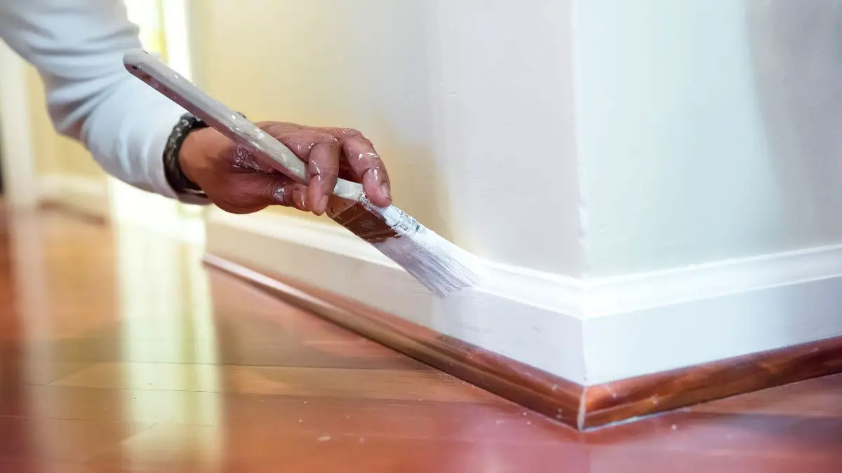 Person painting baseboard