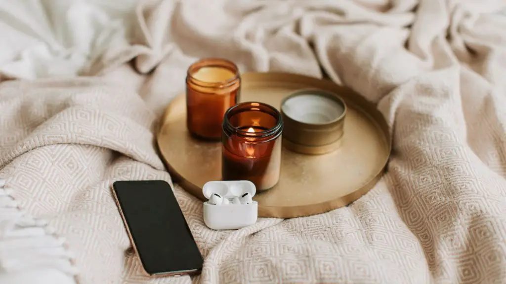 Gadgets and Scented Candles on Bronze Tray